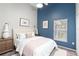 Charming bedroom featuring a blue accent wall, large window, and stylish furnishings at 436 China Berry Cir, Davenport, FL 33837