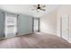 Well-lit primary bedroom features neutral tones, plush carpet and a ceiling fan for comfort at 436 China Berry Cir, Davenport, FL 33837