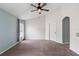 Spacious bedroom with neutral tones, plush carpet, ceiling fan and natural light from the window at 436 China Berry Cir, Davenport, FL 33837