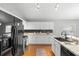 Modern kitchen with white cabinets, stainless steel appliances, black backsplash, and granite countertops at 436 China Berry Cir, Davenport, FL 33837