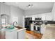 Well-lit kitchen with black appliances, stainless steel stove, sink with breakfast bar and granite countertops at 436 China Berry Cir, Davenport, FL 33837
