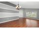 Stylish living room with hardwood floors, modern lighting, and large windows at 436 China Berry Cir, Davenport, FL 33837
