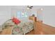 Bright bedroom featuring a ceiling fan, hardwood floors, and natural light from large windows at 4941 Foxdale Dr, Lakeland, FL 33810
