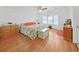 Bright main bedroom features hardwood floors, neutral paint, ceiling fan, and ample sunlight at 4941 Foxdale Dr, Lakeland, FL 33810
