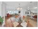 Open-concept dining area features hardwood floors and glass-topped table surrounded by four woven chairs at 4941 Foxdale Dr, Lakeland, FL 33810
