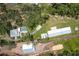Aerial view of a home with pool, garage, driveway, and surrounded by trees at 4949 Lake Kotsa Dr, Lake Wales, FL 33898