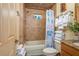 Bathroom featuring a shower/tub combo with nautical themed shower curtain, granite counter, and wood vanity at 4949 Lake Kotsa Dr, Lake Wales, FL 33898