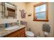 The cozy bathroom has a wood framed window, a granite counter top, and neutral wall color at 4949 Lake Kotsa Dr, Lake Wales, FL 33898