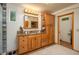 Bathroom featuring wood cabinets with granite counters, decorative lighting, and a doorway to a toilet room at 4949 Lake Kotsa Dr, Lake Wales, FL 33898
