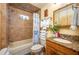 Bright bathroom featuring a shower/tub combo with nautical themed shower curtain, granite counter, and wood vanity at 4949 Lake Kotsa Dr, Lake Wales, FL 33898