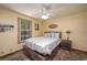 This bedroom has a cozy feel with a window, warm paint, ceiling fan, and wood-look floors at 4949 Lake Kotsa Dr, Lake Wales, FL 33898
