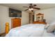 Bright bedroom featuring a large bed, wood furniture, and a ceiling fan with a light at 4949 Lake Kotsa Dr, Lake Wales, FL 33898