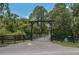 Gated entrance leading to the property, surrounded by mature trees and greenery at 4949 Lake Kotsa Dr, Lake Wales, FL 33898