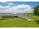 Picturesque lake house accessible by a long wooden dock, surrounded by natural beauty at 4949 Lake Kotsa Dr, Lake Wales, FL 33898