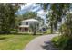 Charming two-story home with a metal roof, inviting front porch, and lush landscaping at 4949 Lake Kotsa Dr, Lake Wales, FL 33898