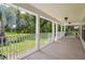 Spacious covered porch with white columns and railing, perfect for outdoor relaxation at 4949 Lake Kotsa Dr, Lake Wales, FL 33898