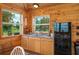 Kitchenette featuring natural wood walls, mini-refrigerator, sink, and cabinets at 4949 Lake Kotsa Dr, Lake Wales, FL 33898