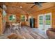 Charming living room featuring natural wood walls, wood ceiling, vinyl floor and a dining area at 4949 Lake Kotsa Dr, Lake Wales, FL 33898