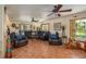 The living room offers leather seating, ceiling fans, and natural light from the large windows at 4949 Lake Kotsa Dr, Lake Wales, FL 33898