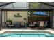 Screened-in pool area with comfortable outdoor seating, a dining table, and a relaxing ambiance at 4949 Lake Kotsa Dr, Lake Wales, FL 33898
