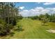 Expansive green property leading to a pond and lake, perfect for outdoor enjoyment at 4949 Lake Kotsa Dr, Lake Wales, FL 33898
