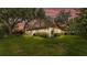 Evening view of a landscaped backyard with lush lawn and mature trees at sunset at 527 Duchess Dr, Lakeland, FL 33803