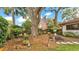 Inviting backyard space with mature trees, flowers, and a seating area at 527 Duchess Dr, Lakeland, FL 33803