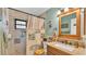 Well-lit bathroom with granite countertops, a wood-framed mirror and tiled shower at 527 Duchess Dr, Lakeland, FL 33803