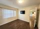 Bright bedroom with wood floors, large window, and convenient access to the hallway, offering comfort at 550 E Thelma St, Lake Alfred, FL 33850