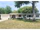 Charming single-story home with a well-kept lawn and a pop of color from the bright blue front door at 550 E Thelma St, Lake Alfred, FL 33850