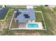 Aerial view of house featuring a pool, solar panels, fenced yard, and paver patio at 607 S 16Th St, Haines City, FL 33844