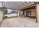 Expansive backyard patio with outdoor kitchen, pergola, pavers, and comfortable wicker sofa at 607 S 16Th St, Haines City, FL 33844