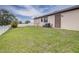 Backyard featuring a well-maintained lawn, AC, door access, and white fence at 607 S 16Th St, Haines City, FL 33844