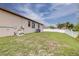 View of the property's backyard, showing the lawn, utilities, and fence at 607 S 16Th St, Haines City, FL 33844