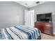 Bedroom with wood-look flooring with television, and lots of neutral light from windows at 607 S 16Th St, Haines City, FL 33844