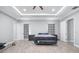 Spacious bedroom featuring a tray ceiling, ceiling fan, ensuite access, and light gray walls and flooring at 607 S 16Th St, Haines City, FL 33844