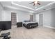 Spacious bedroom featuring a tray ceiling, ceiling fan, ensuite access, and light gray walls and flooring at 607 S 16Th St, Haines City, FL 33844