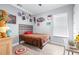 Cute bedroom features hardwood floors, light from a window, and colorful posters at 607 S 16Th St, Haines City, FL 33844