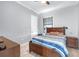 Comfortable bedroom featuring wood flooring, a ceiling fan and a relaxing blue striped comforter at 607 S 16Th St, Haines City, FL 33844