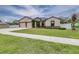 Inviting home featuring a two-car garage, neutral paint, stone accents, and a well-maintained lawn at 607 S 16Th St, Haines City, FL 33844