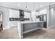 Bright kitchen features a large island, white cabinetry, mosaic backsplash, stainless steel appliances, and wood-look floors at 607 S 16Th St, Haines City, FL 33844