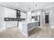 Bright kitchen features a large island, white cabinetry, mosaic backsplash, stainless steel appliances, and wood-look floors at 607 S 16Th St, Haines City, FL 33844