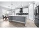 Bright kitchen with white cabinets, island, mosaic backsplash and stainless-steel refrigerator at 607 S 16Th St, Haines City, FL 33844