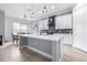 Bright kitchen features a large island with pendant lighting, white cabinetry, tile backsplash, and wood-look floors at 607 S 16Th St, Haines City, FL 33844