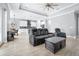 Open-concept living room and kitchen featuring neutral paint, modern lighting, tile floors, and a tray ceiling at 607 S 16Th St, Haines City, FL 33844