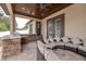 Covered patio featuring a stone kitchen with a built-in grill and cozy wicker furniture at 607 S 16Th St, Haines City, FL 33844