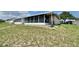 Backyard view of an enclosed lanai and lush green lawn at 615 Ridge Ter # 615, Winter Haven, FL 33881