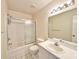 Bright bathroom with a shower and tub combination, white tiled floors, and a large mirror at 615 Ridge Ter # 615, Winter Haven, FL 33881