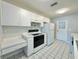 Clean kitchen with white appliances, white cabinets, plenty of countertop space, and tile flooring at 615 Ridge Ter # 615, Winter Haven, FL 33881
