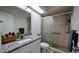 Bathroom with granite countertop, sliding glass doors on the shower and modern fixtures at 624 N Lanier Ave, Fort Meade, FL 33841